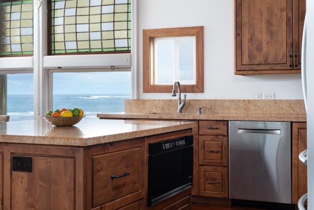 kitchen with dishwasher, a water view, and a wealth of natural light