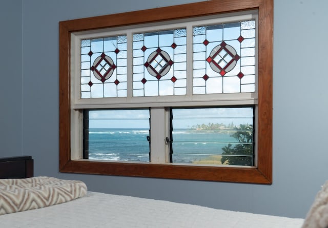 bedroom with a water view and multiple windows