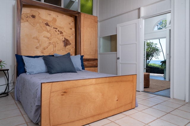 bedroom with light tile patterned floors and wooden walls