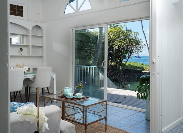 interior space with built in shelves, a water view, and light tile patterned floors