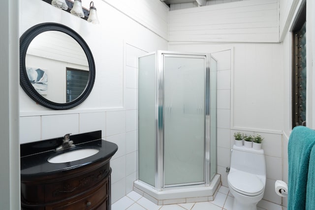 bathroom with tile patterned floors, vanity, walk in shower, and tile walls