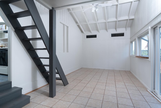 staircase featuring tile patterned floors, lofted ceiling with beams, and ceiling fan