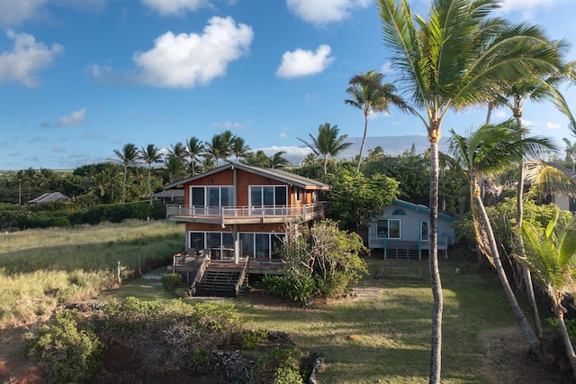 back of property with a yard and a balcony