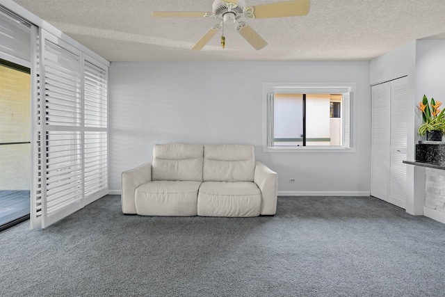 sitting room featuring carpet flooring, ceiling fan, and a textured ceiling