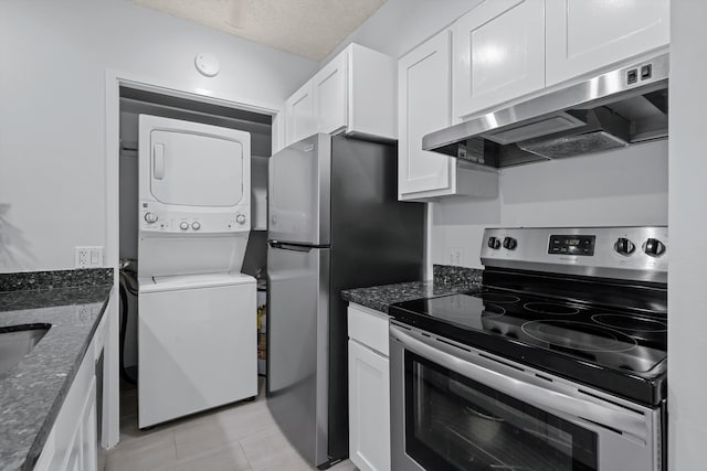 kitchen featuring white cabinetry, stacked washer and dryer, extractor fan, and stainless steel appliances