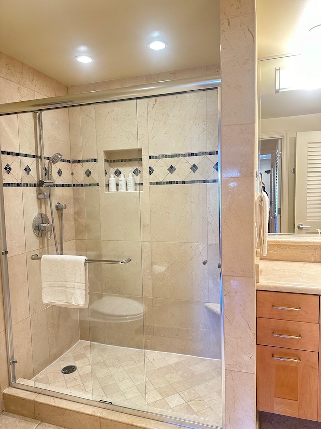 bathroom featuring vanity and a shower with shower door