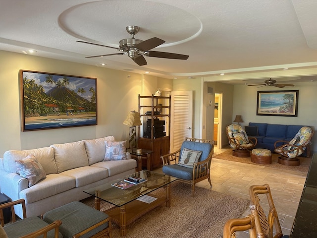 living room featuring a textured ceiling and ceiling fan