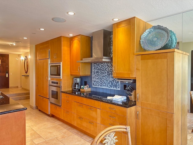 kitchen featuring dark stone countertops, black electric stovetop, tasteful backsplash, stainless steel oven, and wall chimney exhaust hood