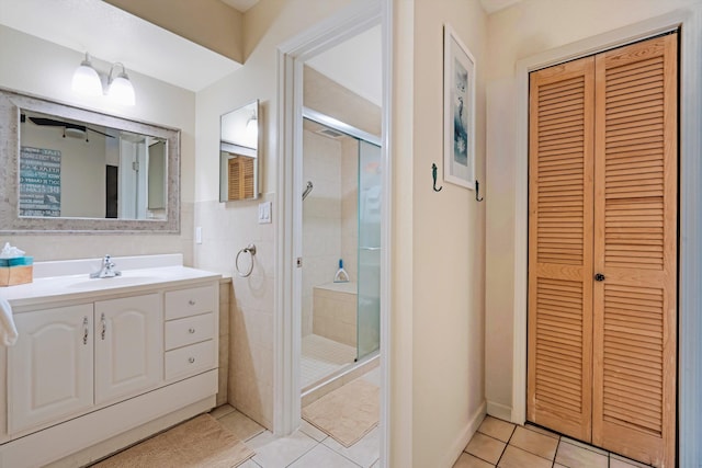 bathroom with tile patterned floors, a shower with shower door, and vanity