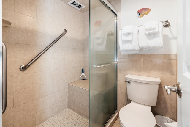 bathroom featuring walk in shower, tile walls, and toilet