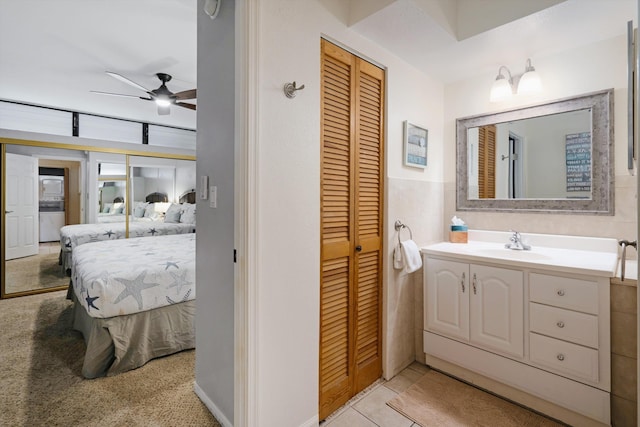 bathroom featuring vanity, tile walls, and ceiling fan