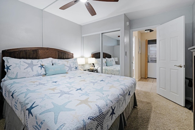 tiled bedroom featuring stacked washer / dryer, ceiling fan, and a closet