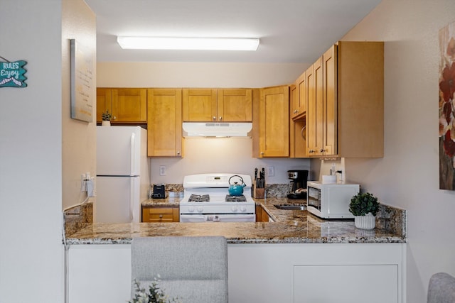 kitchen featuring white appliances, kitchen peninsula, and stone counters