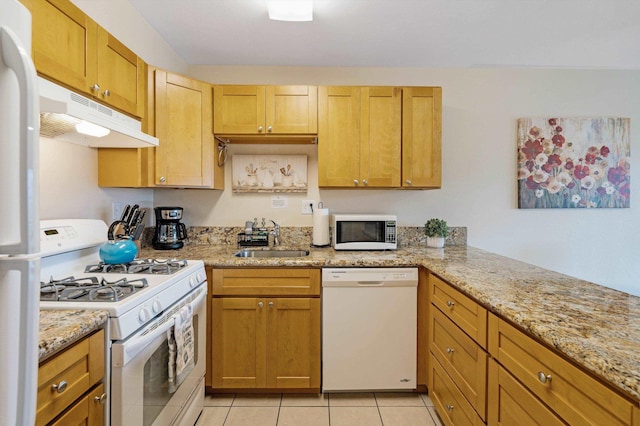 kitchen with sink, white appliances, light stone countertops, and light tile patterned floors