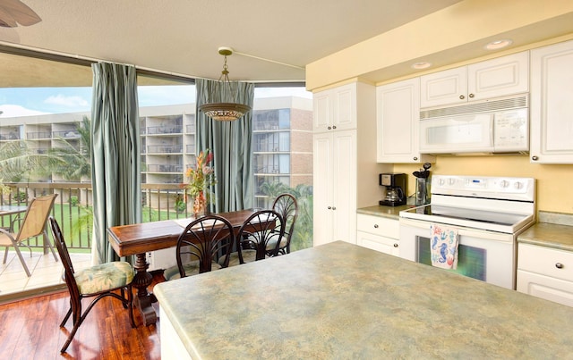 kitchen with plenty of natural light, white cabinets, and white appliances