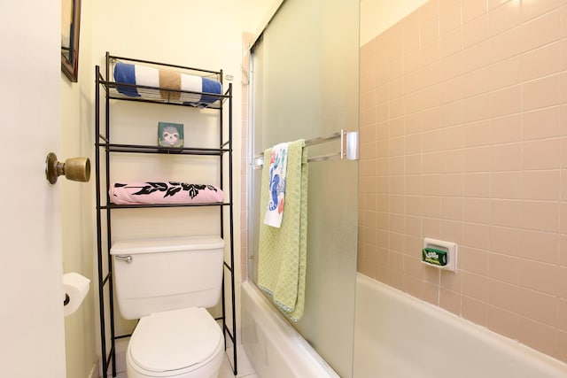 bathroom featuring tile floors, toilet, and enclosed tub / shower combo