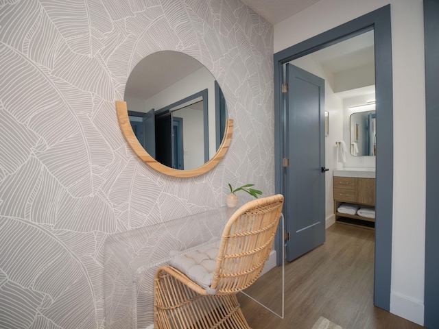 hallway with dark wood-style floors, baseboards, and wallpapered walls