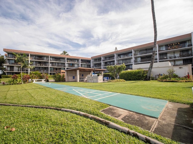 view of home's community featuring shuffleboard and a lawn