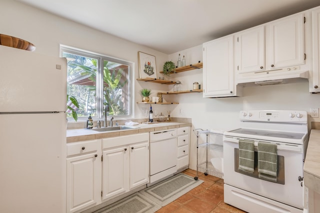 kitchen featuring white appliances, a sink, white cabinetry, and under cabinet range hood