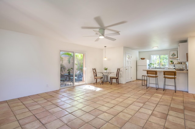 living area with ceiling fan and light tile patterned flooring