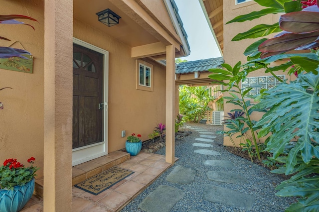 doorway to property with a tiled roof and stucco siding