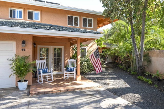 exterior space featuring french doors, fence, a tiled roof, and stucco siding