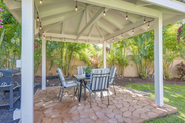 view of patio with outdoor dining space, a fenced backyard, a grill, and a gazebo