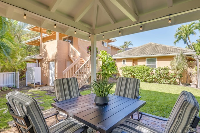 view of patio with stairs, a gazebo, and outdoor dining space