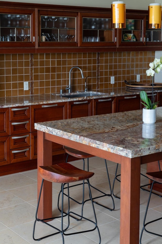93 Makakehau St Unit G5, Kihei, HI 96753 - kitchen with a sink, a kitchen bar, tasteful backsplash, light tile patterned flooring, and light stone counters