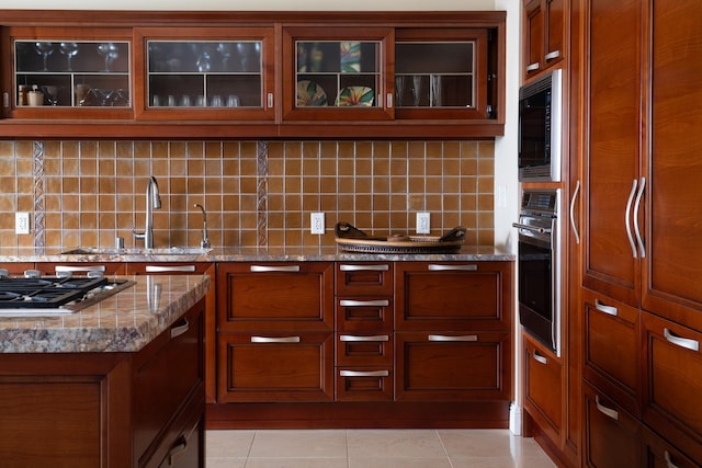 93 Makakehau St Unit G5, Kihei, HI 96753 - kitchen with wall oven, stainless steel gas stovetop, brown cabinetry, and backsplash