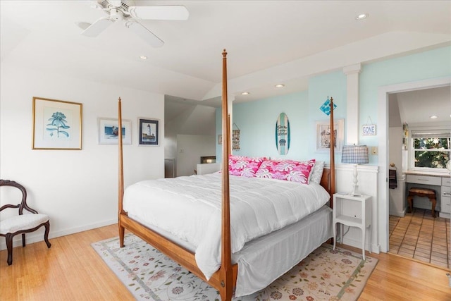 bedroom with ceiling fan, vaulted ceiling, and light hardwood / wood-style floors