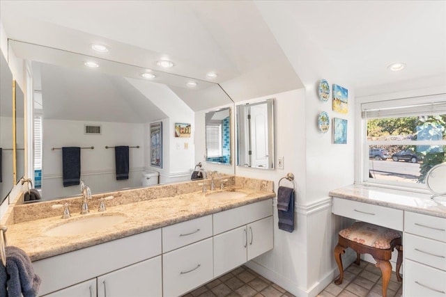 bathroom featuring vanity and lofted ceiling