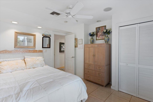 tiled bedroom with ceiling fan and a closet