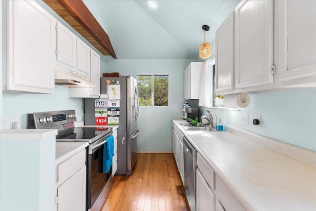 kitchen with stainless steel appliances, light hardwood / wood-style floors, white cabinetry, hanging light fixtures, and lofted ceiling