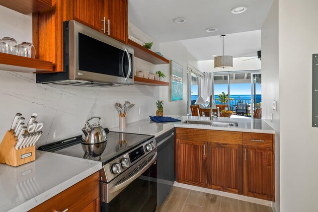 kitchen featuring sink, decorative backsplash, hanging light fixtures, and stainless steel appliances