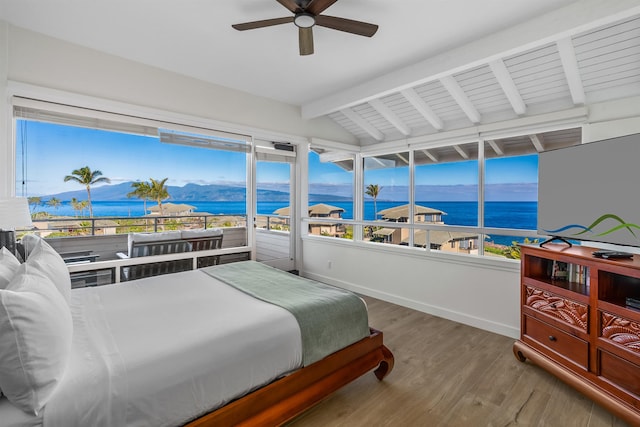 bedroom featuring a mountain view, ceiling fan, hardwood / wood-style floors, and lofted ceiling with beams