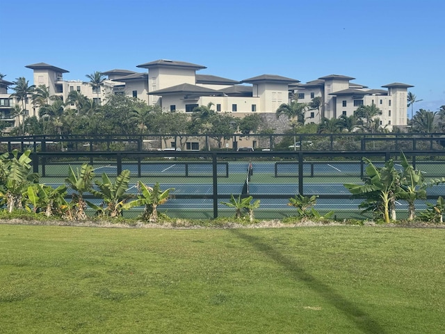 view of sport court with a lawn