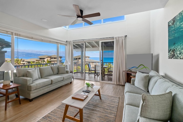 living room with ceiling fan, a water and mountain view, and light wood-type flooring