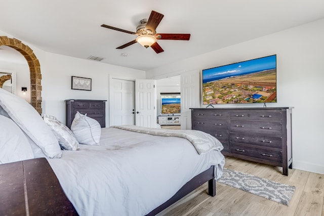 bedroom featuring visible vents, baseboards, light wood-style floors, and ceiling fan