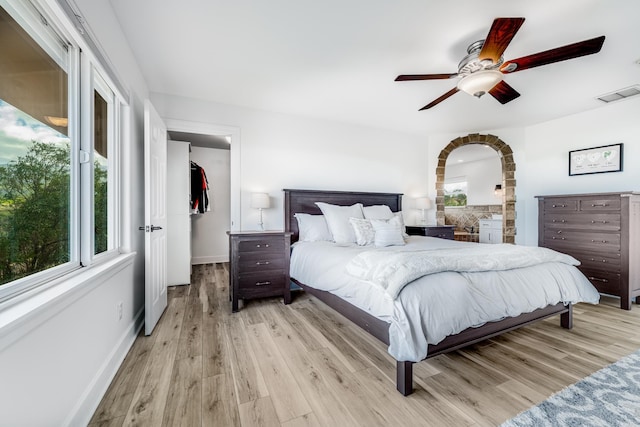 bedroom with ceiling fan, wood finished floors, visible vents, and baseboards