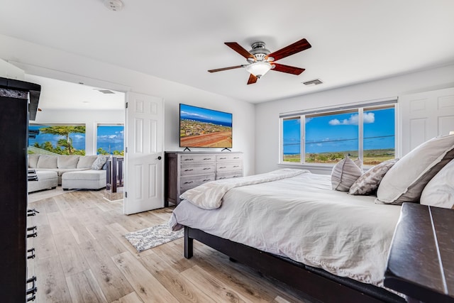 bedroom featuring visible vents, multiple windows, a ceiling fan, and wood finished floors