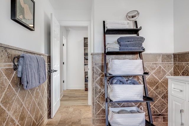 bathroom featuring wainscoting and tile walls