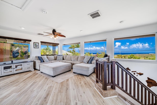 living area featuring visible vents, a ceiling fan, and light wood-style floors