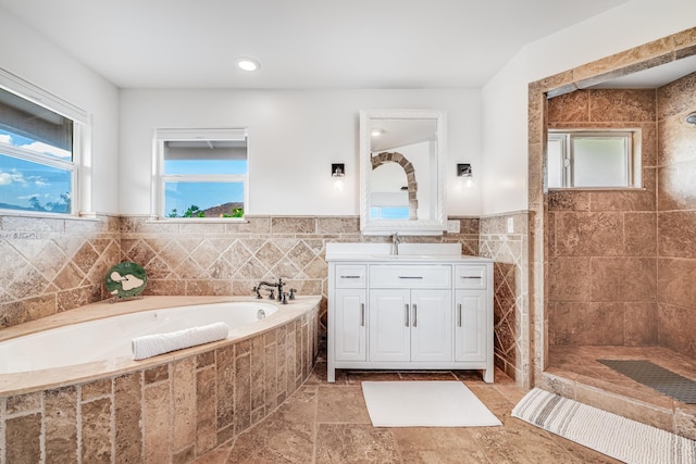 full bathroom featuring stone tile flooring, tiled shower, vanity, and a garden tub