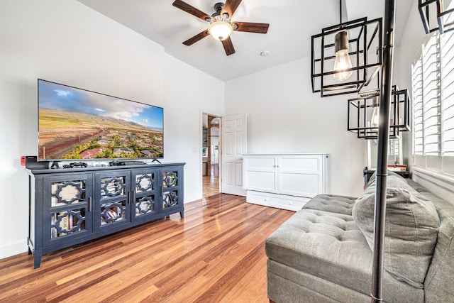 living room with baseboards, ceiling fan, and wood finished floors