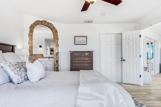 bedroom with wood finished floors, visible vents, ceiling fan, a closet, and ensuite bathroom