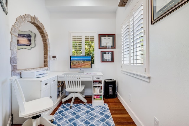 office space with dark wood-type flooring, plenty of natural light, and baseboards