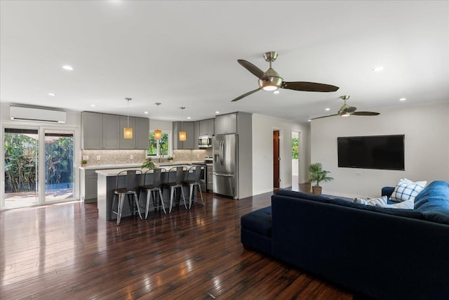 living room with ceiling fan, a wall mounted air conditioner, and dark hardwood / wood-style floors