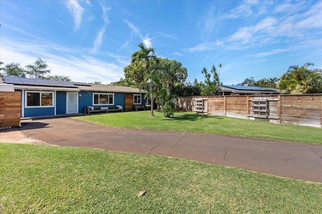 ranch-style house with a front lawn and solar panels