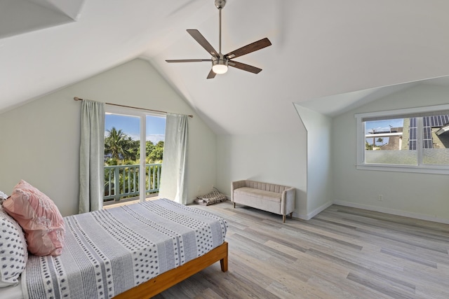 bedroom featuring vaulted ceiling, multiple windows, baseboards, and wood finished floors